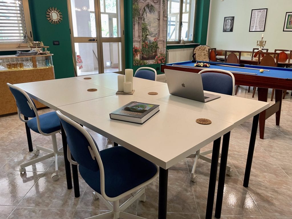 The dining room showing the La Vita Sukha co-working station as a close up detail with a vintage bar in the background
