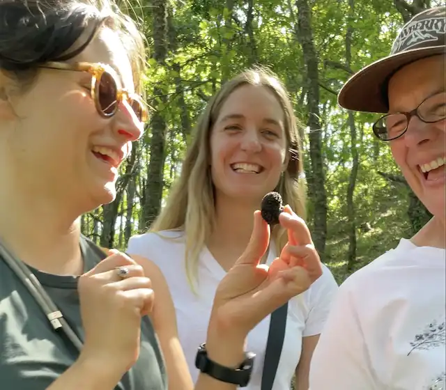 Three girls holding a freshly-hunted truffle whilst participating in a truffle hunt at La Vita Sukha in Roseto Valfortore, Puglia, Italy.